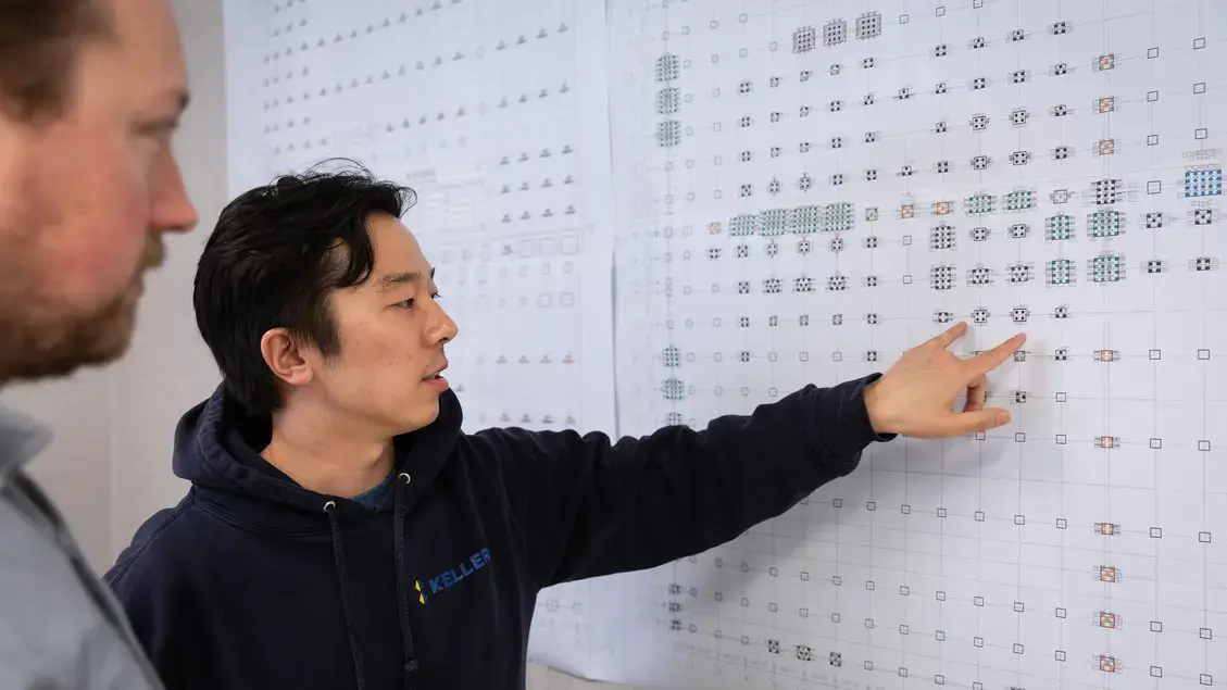 Two men examining a layout
