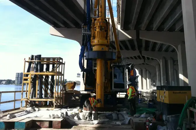 Installing drilled shafts between two bridges