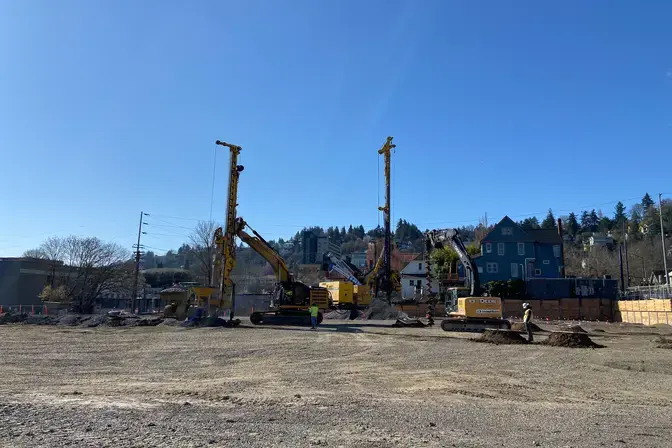 several rigs on a construction site with a blue sky