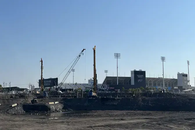construction site in front with distant football stadium in the background