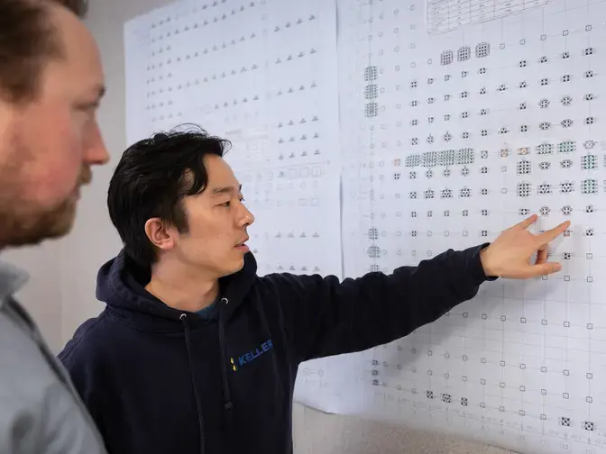 Two men examining a layout