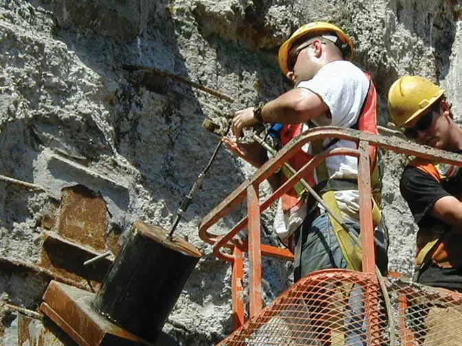 man grouting around anchor of trade center foundation