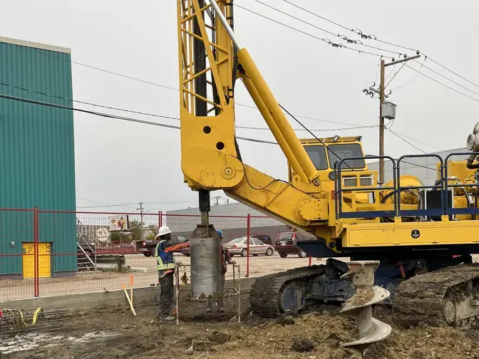 drilling on job site with yellow rig