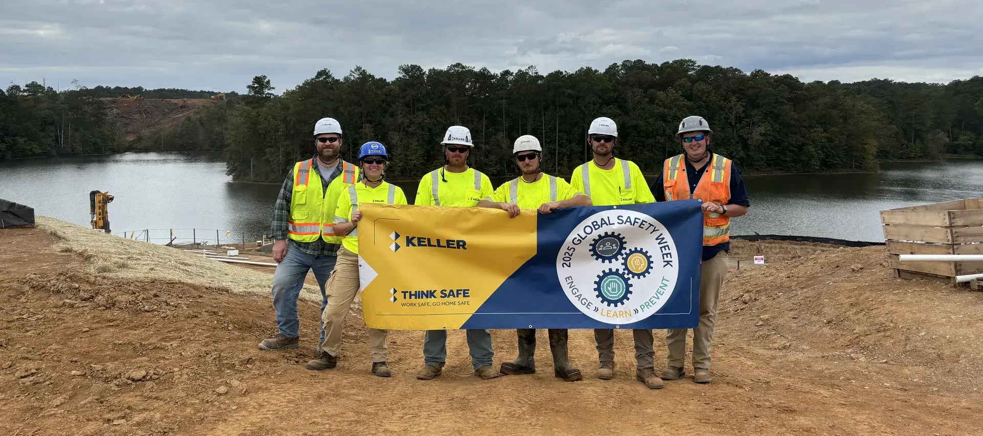 Six Keller employees holding a banner on site