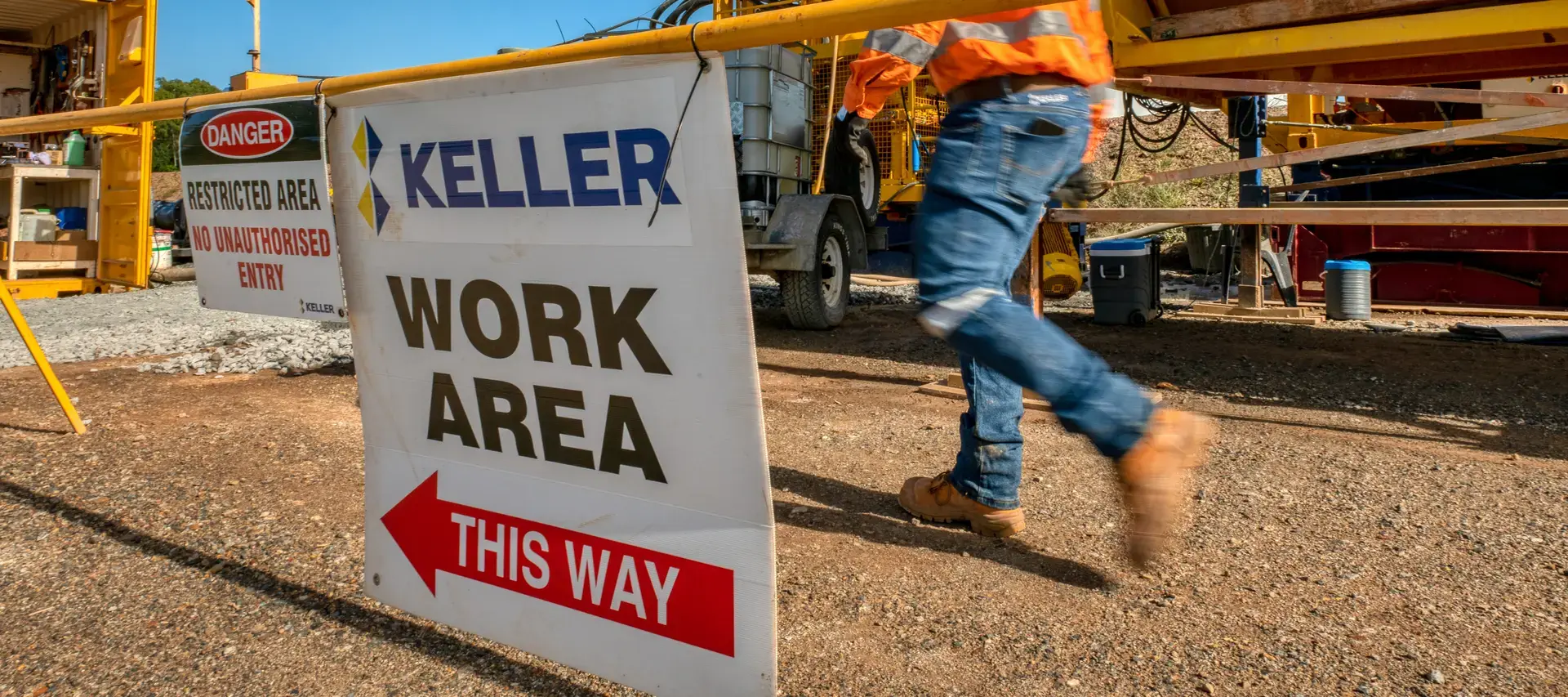 Keller worker walking past a 'Work area this way' sign