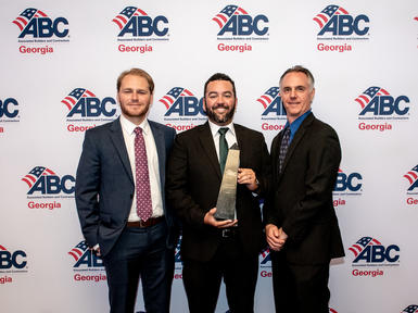 three men in suits with award