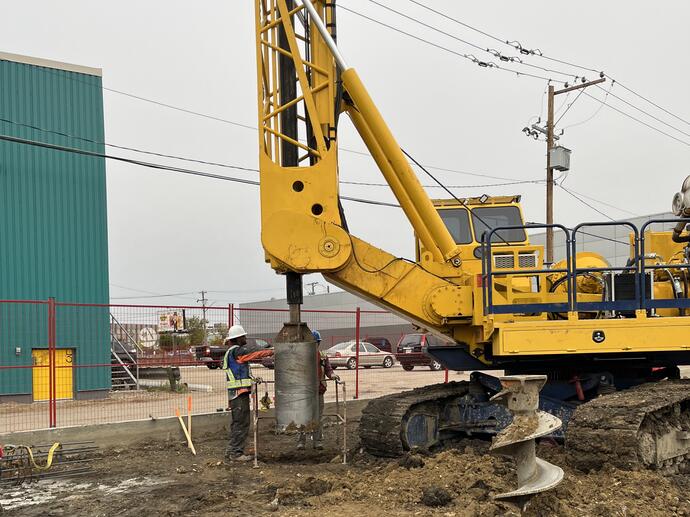 drilling on job site with yellow rig