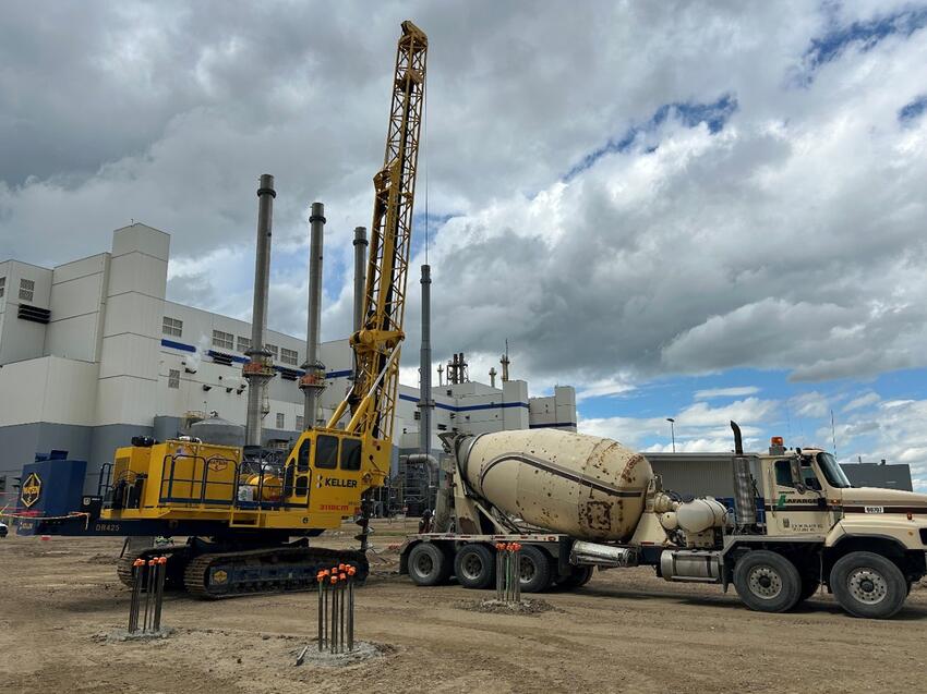yellow drill rig and white concrete truck